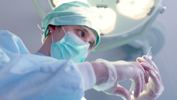 Doctor Preparing Syringe For Injection