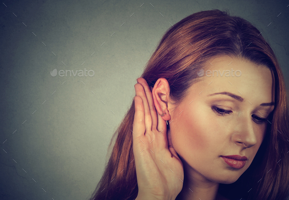 Woman holds her hand near ear and listens carefully