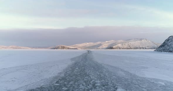 Drone Following a Icebreaker on Surface of Frozen Lake Baikal. Blue Sky and White Snow. alt