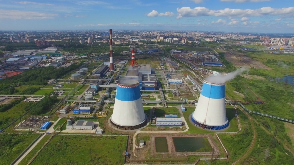 aerial view of power plant with large pipes on background of the city