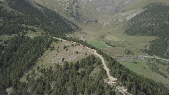 Aerial footage of drone flying above Rock Del Quer in The Pyrenees mountains of Andorra in summer