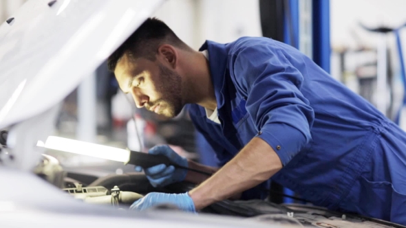 Mechanic Man With Lamp Repairing Car At Workshop 29