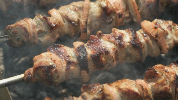 Meat Prepares On Metal Skewers On Coals Outdoors