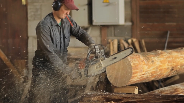 Motor Chainsaw Cutting Wooden Beam. Man Work With Wood House