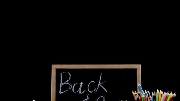 Pot plant and digital tablet with school supplies on table alt