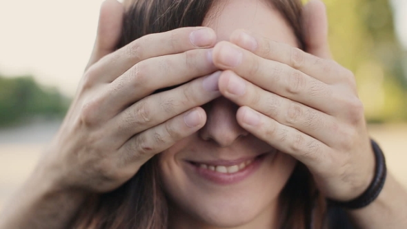Man Covering The Eyes Of Surprised Girlfriend