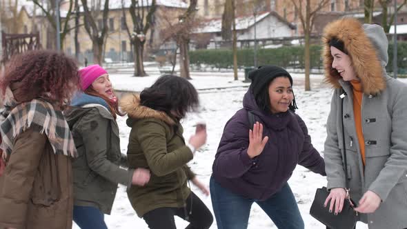 slow motion five young women multiethnic outdoor snow field having fun dancing alt