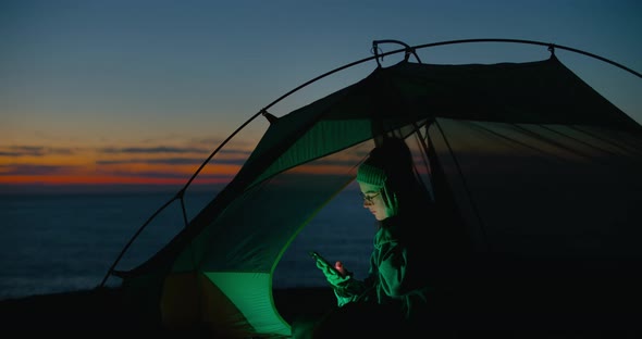 Lonely Young Woman Look at Phone in Camping Tent