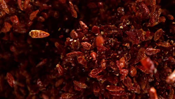 Super Slow Motion Shot of Dried Red Chili Peppers Explosion on Black Background at 1000Fps alt