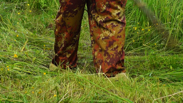 Farmer Mowing Grass Using a Scythe