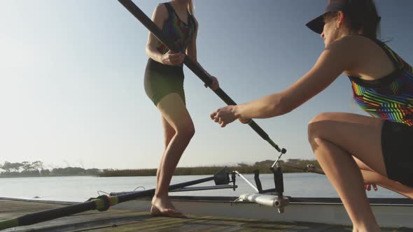 Female rowers training on a river alt