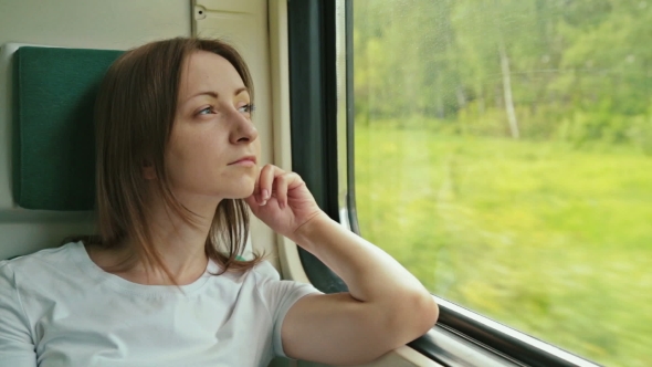 Young Woman Looking Out The Window Of a Train