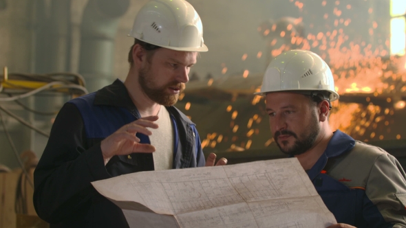 Portrait Of Two Engineers Explore And Discuss Project In Heavy Industry Factory. Welding Background alt