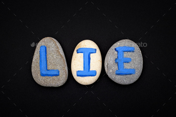 Word Lie spell out from stones with blue letters