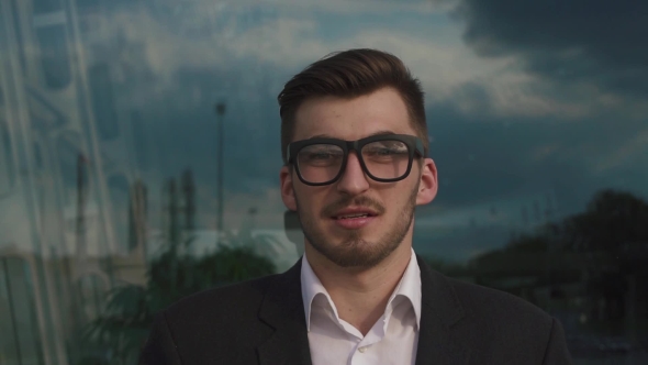 Face Of Confident Handsome Elegant Businessman Staring At The Camera In Glasses. Outdoor Airport