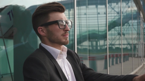 Side View Of An Attractive Businessman Takes Off Glasses And Being Worried And Thoughtful While