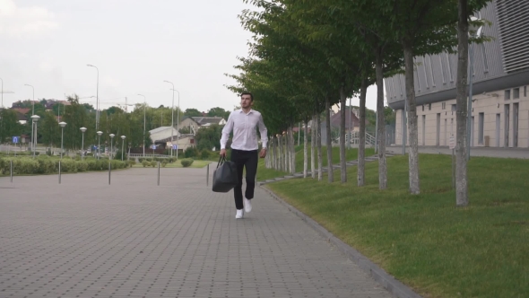 Front View Of Handsome Elegant Businessman In White Shirt Running With Big Suitcase In . Urban City