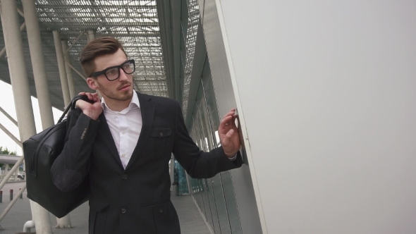 Business Passenger Waiting For His Flight. Male Businessman Model In Glasses On The Urban Airport