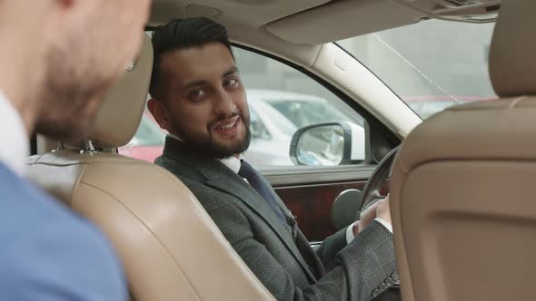Mixed-Race Luxury Car Driver Talking to Passenger alt
