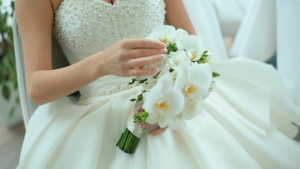 Beautiful Bride Is Holding White Wedding Bouquet. Bridal Accessories. Details For Marriage