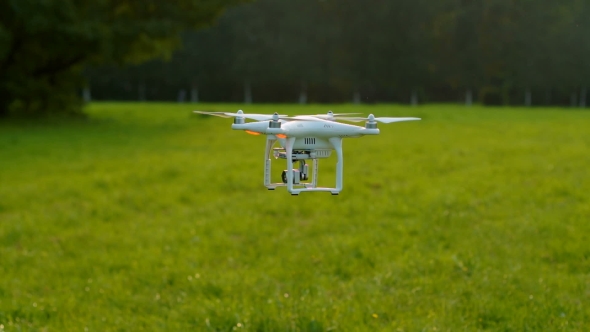 RC quadcopter with camera flies up from the lawn