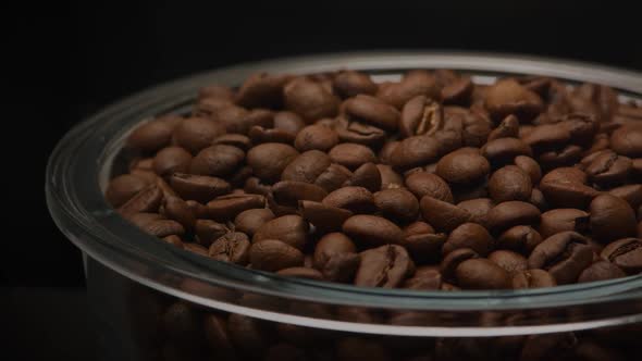 Close Up Slow Camera Pan Over a Glass Plate Filled with Coffee Beans on a Dark Background alt