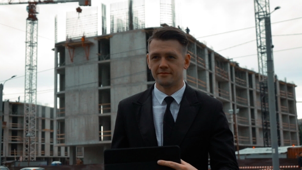 Businessman Using Digital Pad Near New Construction alt