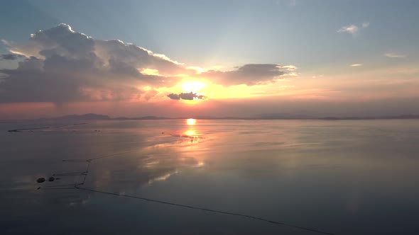 Sunset in Mesologgi Greece. Aerial view of the sunset behind clouds and sea horizon. alt