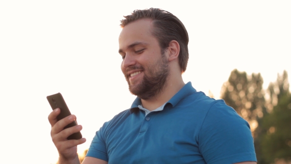 Smiling Bearded Man Using Smartphone Outdoor