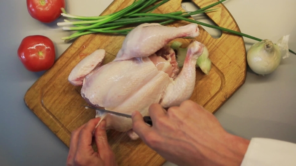 Male Hands Preparing Whole Raw Chicken On a Wooden Cooking Board