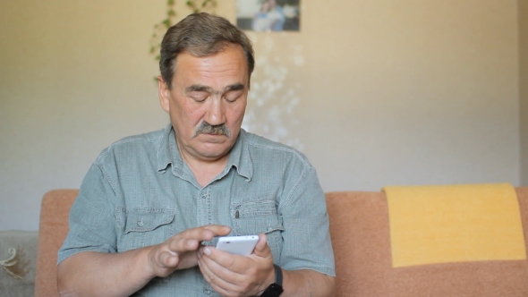 Senior Man With a Mustache Touching The Mobile Phone. He Wrote In The Social Network