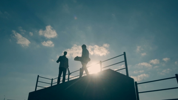 Friends Hang Out At Skate Park On Summer Day While Boy Goes Down On Skateboard Ramp. alt