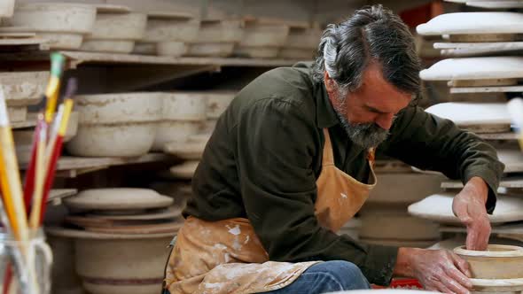 Male potter moulding clay 4k alt