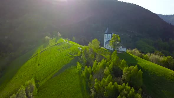 Drone footage sunset at Church of St. Primus and Felician, Jamnik, Slovenia alt