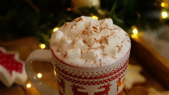 Closeup dolly shot of Christmas mug with hot chocolate, marshmallow and cinnamon