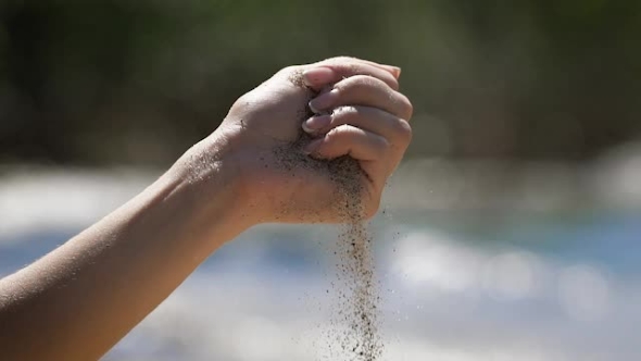 The  Snapshot Of Hand With Sand Strewed To Fingers. alt