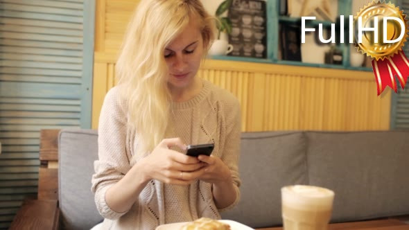Young Woman Typing a Message on Smart-Phone in a