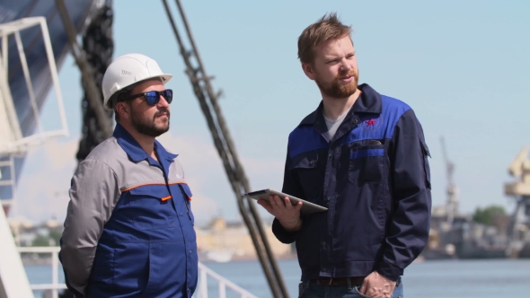 Two Engineers With Laptop Communicate In Shipping Cargo Port