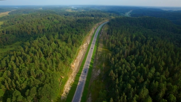 Aerial View Of Cars Driving On a Road In The Woods alt