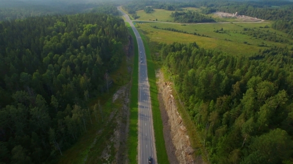 Aerial View Of Cars Driving On a Road In The Woods