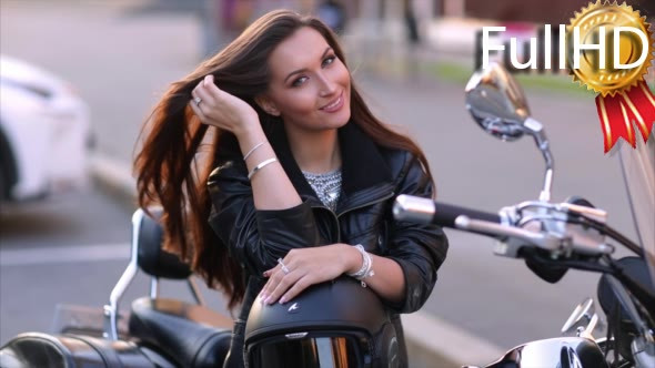 Woman Biker Smiles and Straightens Hair Sitting