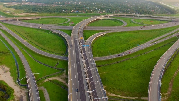 Aerial view of highway surrounded by green fields
