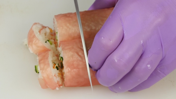 Cook Prepares The Rolls Cut Pieces.  alt