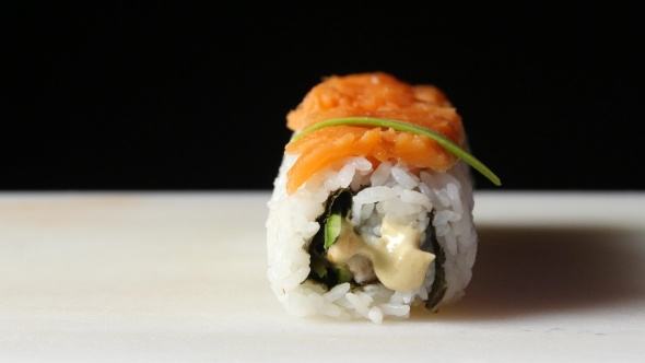 Chef Decorates The Roll With Pieces Of Avocado alt
