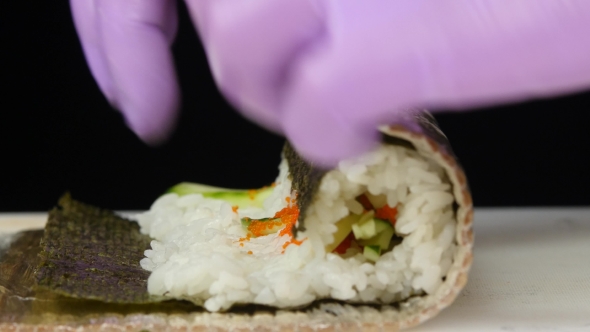 Chef Wraps The Roll With The Mat.  alt