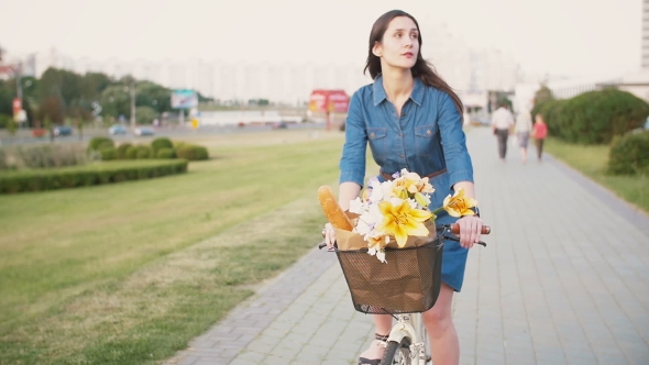 Brunette Girl Cycling With Flowers In a Basket And Exploring The City, , Steadicam Shot alt