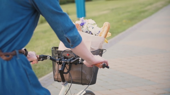 Girl Hands On a Handlebar Of a Bicycle, Flowers And Bread In a Basket, Cycling In The City alt