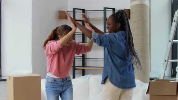 Women with Boxes Moving in New Home and Dancing alt