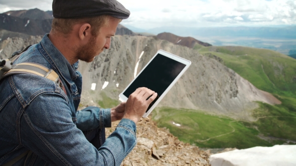 Man Working Outdoors With Tablet Computer