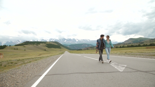 Best Friends Having Fun With Skateboard On Open Road. Young Man And Woman Longboarding Together On a alt